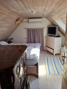 1 dormitorio con 1 cama y escritorio con TV en Balatoncsicsó - Szőlő Birtok, en Balatoncsicsó