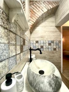 a bathroom with a large rock sink in it at Republique Apartment in Braşov