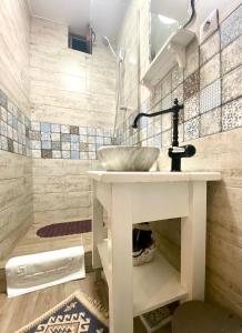 a bathroom with a white sink and a shower at Republique Apartment in Braşov