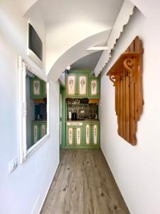 a hallway in a house with green cabinets and a window at Republique Apartment in Braşov
