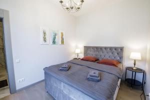 New apartment LOFT MAJORI with terrace في يورمالا: غرفة نوم مع سرير كبير مع وسائد برتقالية