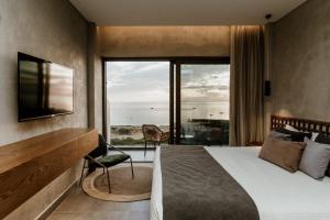 a hotel room with a bed and a large window at Cavo Zoe Seaside Hotel in Protaras