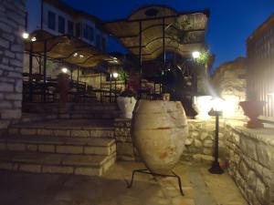 a large stone vase sitting in front of a building at Hotel Klea in Berat