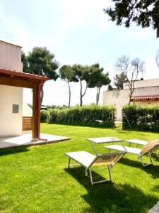 2 Liegestühle und ein Tisch im Hof in der Unterkunft Villa Costanza in Bari
