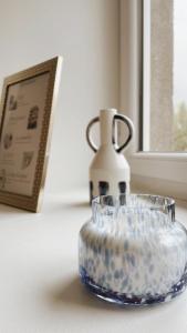 a glass vase sitting on a table next to a window at Ar Maen in Lanvollon