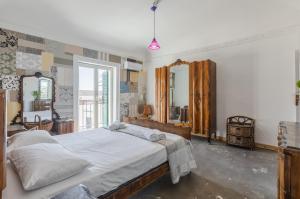 a bedroom with a large bed and two mirrors at Ballarò Market Street Art Stylish Flat x10 in Palermo