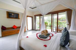 a bedroom with a bed with a flower arrangement on it at Villa Capung Mas Ubud in Ubud