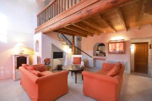 een woonkamer met 2 oranje stoelen en een tafel bij Le Mas Saint Pierre - 10 personnes in Cabannes