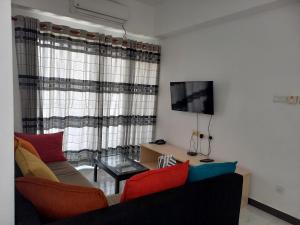 a living room with a couch and a tv at Ivy Apartment- Lotus in Mount Lavinia