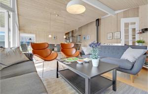 a living room with a couch and a table at Beautiful Home In Væggerløse With Sauna in Marielyst