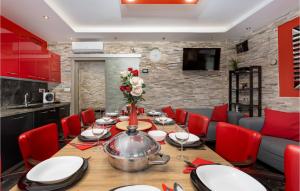 a dining room with a table and red chairs at Nice Home In Vantacici With Wifi in Porat