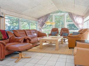 エーベルトフトにある10 person holiday home in Ebeltoftのリビングルーム(ブラウンレザーの家具、窓付)
