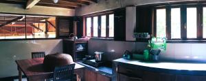 a kitchen with a table and windows in a room at Happy Ria Homestay & Guesthouse in Bukit Lawang