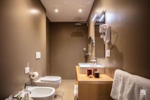 uma casa de banho com um lavatório, um WC e um espelho. em The Lady C - High Apartments em Tropea