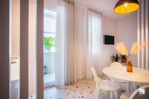 uma sala de jantar com uma mesa e cadeiras e uma janela em The Lady C - High Apartments em Tropea