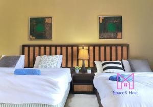 two beds sitting next to each other in a bedroom at Gold Coast Morib Resort in Banting +176 photos