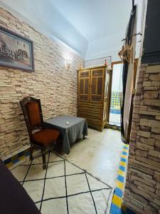 a room with a table and a chair and a brick wall at Archduke private rooms in Marrakech +31 photos