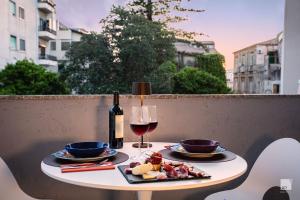 uma mesa com um prato de comida e um copo de vinho em The Lady C - High Apartments em Tropea
