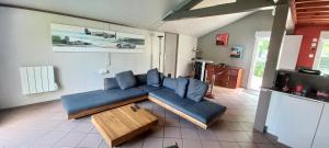 a living room with a blue couch and a table at Belle maison - 5 chambres 4 sdb - proche circuit et pôle européen du cheval - idéal groupes & familles in Champagné +18 photos