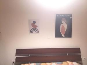 een slaapkamer met een bed en twee foto's aan de muur bij Appartment in Nea Erithrea in Athene