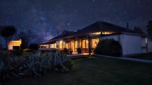 ein Haus in der Nacht mit Sternenhimmel in der Unterkunft Te Anau Manapouri Lake Hotel in Manapouri