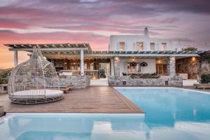 a villa with a swimming pool and a house at El Sueno Villa Mykonos in Kalafatis