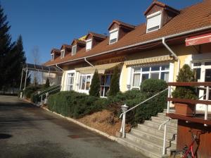 a white house with a brown roof at Club Torony Hotel in Torony
