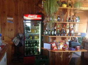 un frigorifero con coca cola in una stanza con bottiglie di alcol di Club Torony Hotel a Torony