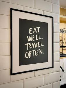 une image encadrée sur un mur avec les mots manger bien voyager souvent dans l'établissement Luxury 2BR Flat in Hip Notting Hill, à Londres