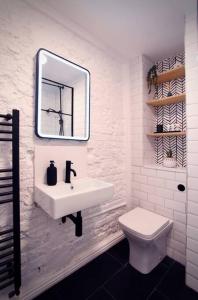 Luxury 2BR Flat in Hip Notting Hill في لندن: حمام أبيض مع حوض ومرحاض