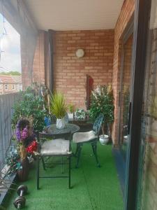 a patio with a table and chairs and plants at Comfy Stay and Relaxing Apart in London