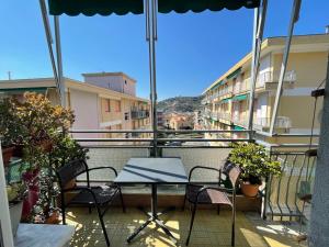 eine Terrasse mit einem Tisch und Stühlen auf dem Balkon in der Unterkunft Nice studio Rapallo ac wi fi in Rapallo