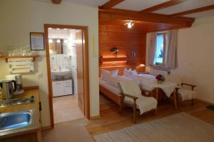 a bedroom with a bed and a table and a bathroom at Haus Schmidberger in Schneizlreuth