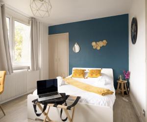 um quarto com uma cama e um computador portátil numa cadeira em Le Petit Vauban em Estrasburgo