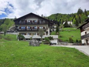 une grande maison au milieu d'un champ verdoyant dans l'établissement Appartamenti Dolomiti, à Colcerver