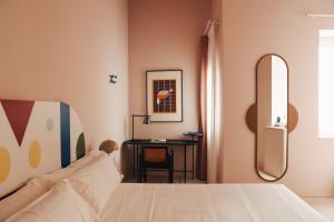 a bedroom with a bed and a desk with a mirror at Casa Clarita in Valencia