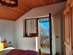 a bedroom with a bed and a large window at Appartamenti Dolomiti in Colcerver