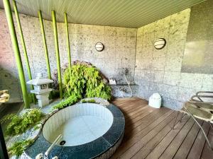 La salle de bains est pourvue d'une baignoire avec des plantes. dans l'établissement SKY LEGEND1 Beppu , Resort Love Hotel, à Beppu