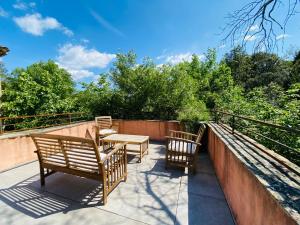 eine Terrasse mit zwei Bänken und einem Tisch auf einem Balkon in der Unterkunft Beauregard Cévennes - Superbe chambre d'hôtes moderne et indépendante in Monoblet + 22 Fotos