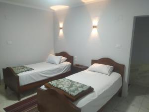 2 camas en una habitación con luces en la pared en فندق هابى دريمز, en El Cairo