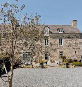 a large stone building with a tree in front of it at Ar Maen in Lanvollon