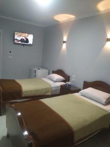 una camera d'albergo con due letti e una TV a parete di فندق هابى دريمز a Il Cairo