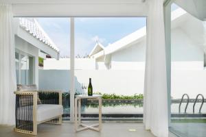 三亞的住宿－三亚亚龙湾迎宾馆别墅，白色的客房设有桌子和玻璃窗