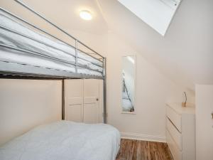 a bedroom with a bunk bed and a dresser at Millport Bay View in Millport