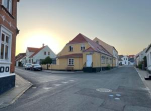 a street with houses and cars parked on the road at Unik ferielejlighed i Marstal. in Marstal