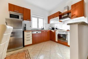 kuchnia z drewnianymi szafkami i urządzeniami ze stali nierdzewnej w obiekcie Villa Andrea with private heathed pool w mieście Debeljak +37 zdjęć