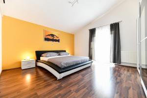 sypialnia z łóżkiem i drewnianą podłogą w obiekcie Villa Andrea with private heathed pool w mieście Debeljak