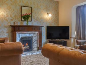 a living room with a fireplace and a television at Melrose in Clitheroe