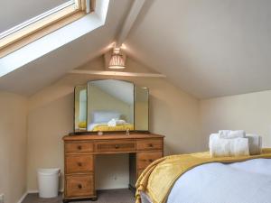 ein Schlafzimmer mit einer Kommode mit einem Spiegel darauf in der Unterkunft Melrose in Clitheroe