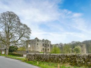 ein altes Schloss mit einer Steinmauer und einer Straße in der Unterkunft Melrose in Clitheroe